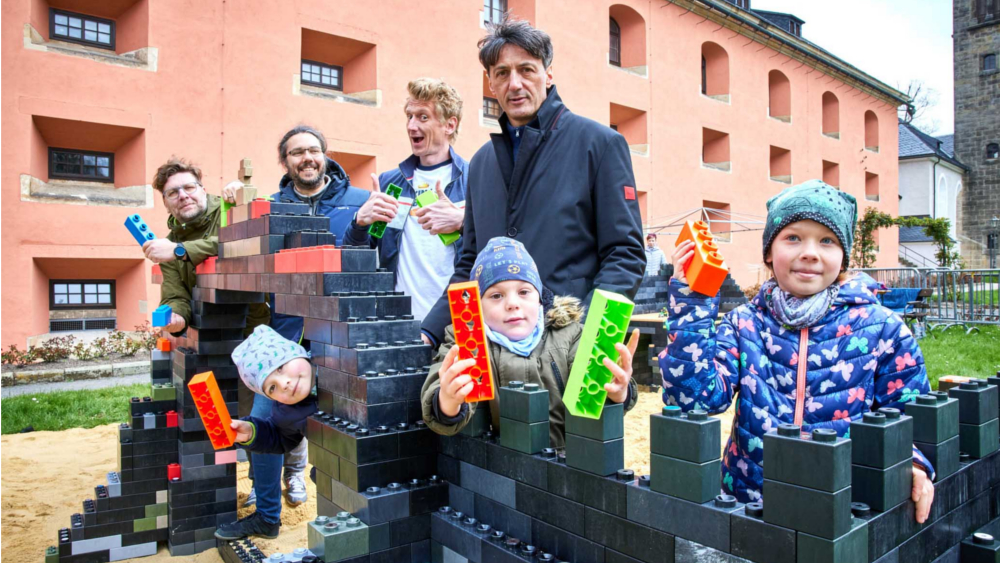(v.l.n.r.) Oliver Tschentscher, Gründer und Inhaber MAXOLI Clever Bricks, Max Stauß, Geschäftsführer Pirnaer Spritzgussfirma 1st Mould GmbH und Hersteller der Maxoli Bricks, Björn Freitag, Gewinner der TV-Sendung „Lego Masters“ und Moderator der Online-Sendung „King of Brixx“, Dr. André Thieme, Geschäftsführer der Festung Königstein gGmbH sowie unten die Kinder: Hugo, Lenny und Abby ©Marko Förster/Festung Königstein gGmbH