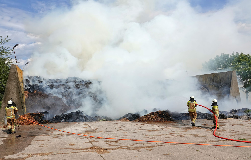 © Roland Halkasch Brandgut mit Feuerwehrleuten im Vordergrund