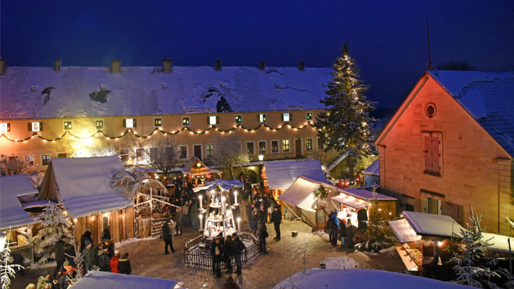 Blick auf die Marktbuden auf dem Paradeplatz vorn die drei Meter hohe Erzgebirgische Weihnachtspyramide ©Festung Königstein gGmbH