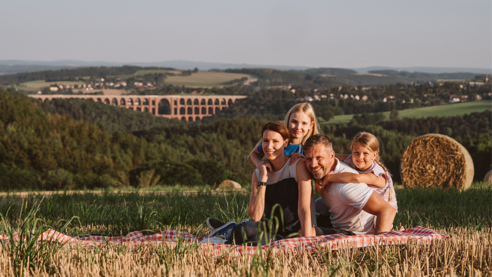 Beim Familien-Picknick genießen die Urlauber den Ausblick auf die Göltzschtalbrücke, das Wahrzeichen des Vogtlands. Foto: DJD/Tourismusverband Vogtland/K. Pool