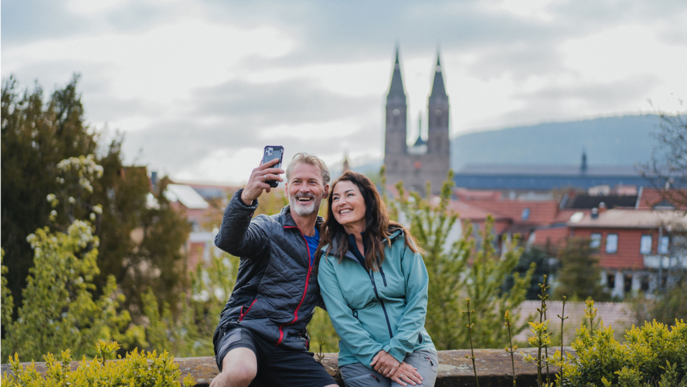 Selfie vor dem Hintergrund von Heilbad Heiligenstadt, der deutschen "Wanderhauptstadt 2024". Foto: DJD/www.dwt2024.de/HVE/Eichsfeld Touristik