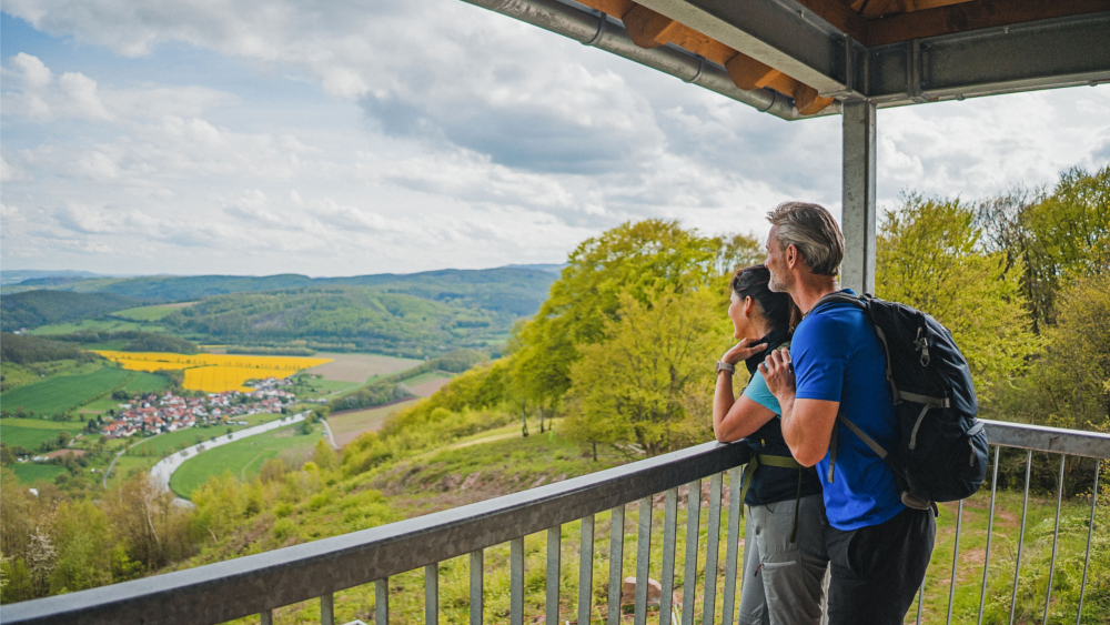 Der Aussichtspunkt Lindewerrablick im Eichsfeld wird auch Ministerblick genannt, weil hier 1984 der damalige DDR-Verteidigungsminister seinem Amtskollegen aus Nordkorea Möglichkeiten zur Grenzbefestigung in schwierigem Gelände zeigen wollte. Heute steht die Region für ein grenzenloses Miteinander. Foto: DJD/www.dwt2024.de/HVE/Eichsfeld Touristik