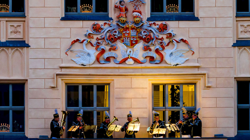 Stimmungsvolles Konzert einer Bläsergruppe in traditioneller Bekleidung auf dem Rathausbalkon am Hauptmarkt in Zwickau. Foto: DJD/Tourismusverband Chemnitz Zwickau Region/Mattrose.de