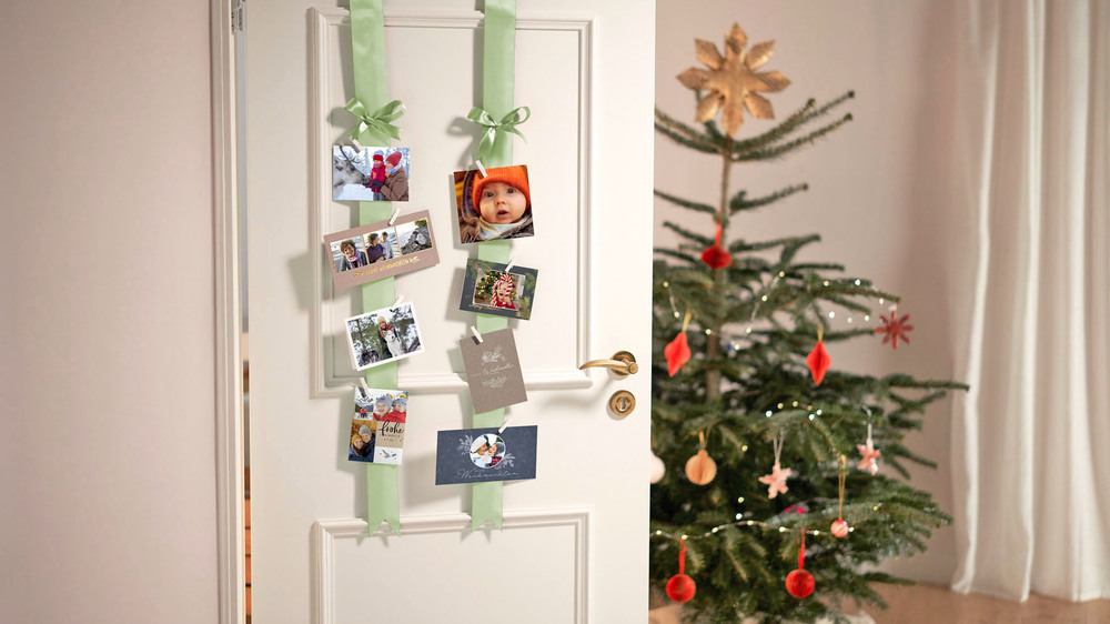 Die passende Dekoration weckt Vorfreude auf Weihnachten. Mit dekorativen Schleifenbändern lassen sich zum Beispiel Foto-Grußkarten stilvoll in Szene setzen. Foto: DJD/www.cewe.de