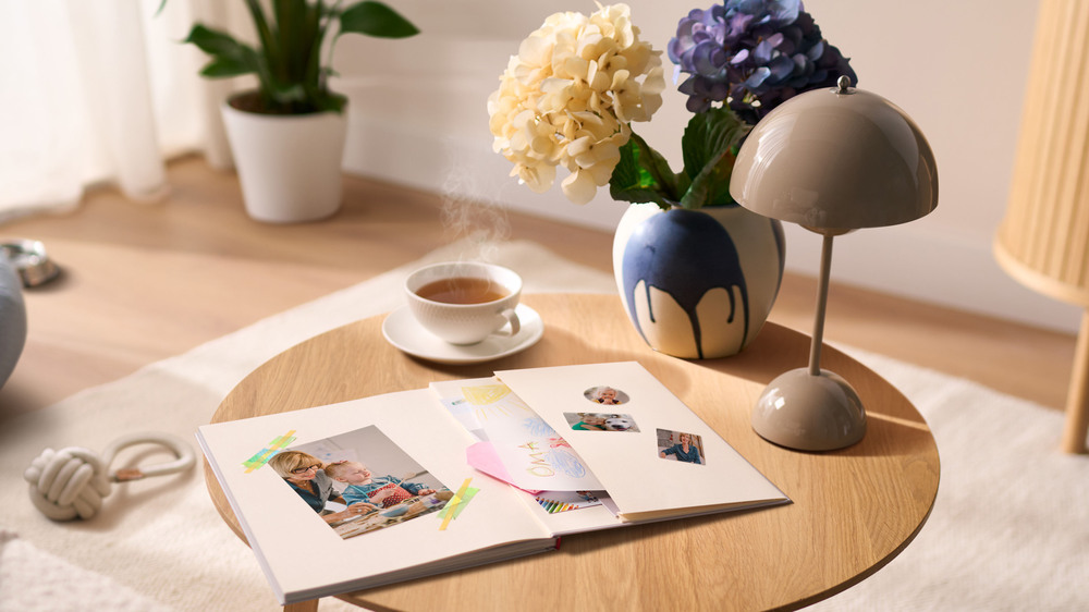 In Erinnerungen schwelgen: Ein Fotobuch mit besonderen Momenten aus dem Familienleben ist eine besondere liebevolle Art, um Mutter einmal "Danke" zu sagen. Foto: DJD/CEWE