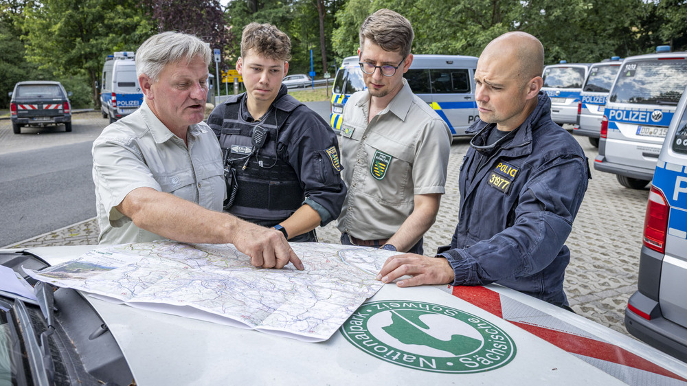Jens Posthoff (1. v. l.) und Alexander Nowak (3. v. l.) von der Nationalpark- und Forstverwaltung Sächsische Schweiz stimmten mit Kollegen der sächsischen und tschechischen Polizei die Routen ab, entlang derer die Einsatzkräfte die Einhaltung des Feuerverbots kontrollierten. Foto: Marko Förster