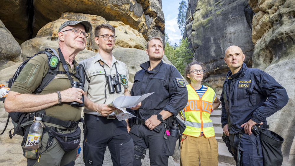 Alexander Nowak (2. v. l.), Leiter der Ranger der Nationalpark- und Forstverwaltung von Sachsenforst, kontrollierte mit Beamten der deutschen und tschechischen Polizei (1. und 3. v. r.) die Einhaltung des Feuerverbots im Gebiet des Nationalparks Sächsische Schweiz. Die zweisprachige Kommunikation unterstützte eine Dolmetscherin (2. v. r.). Foto: Marko Förster