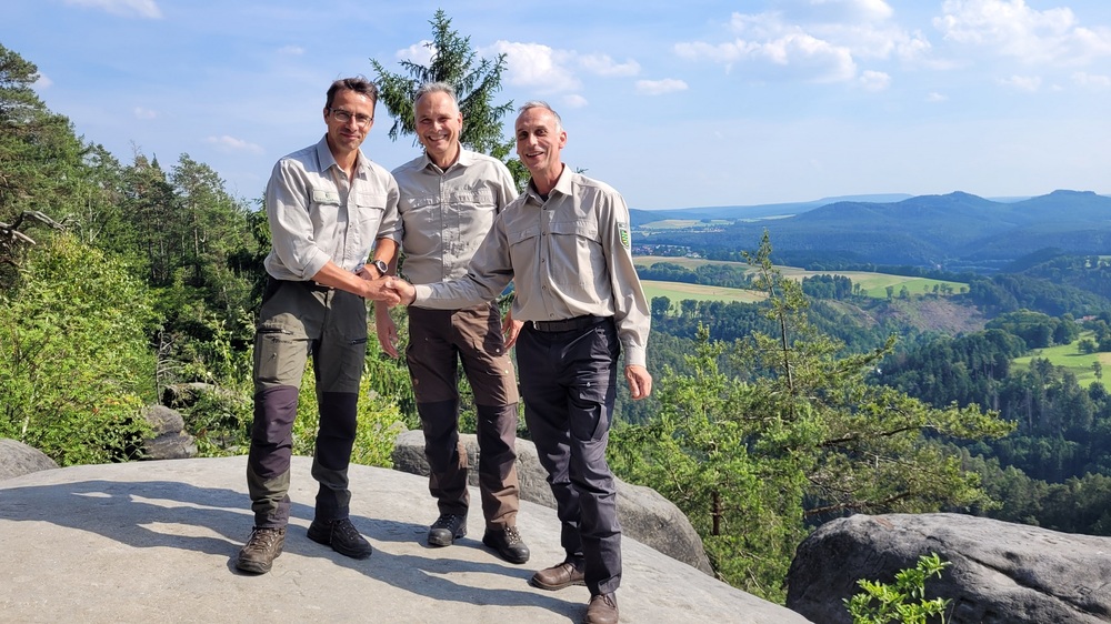 Zum 1. Juli 2025 übernahm Daniel Thomann (r.) von seinem Vorgänger Sascha Schlehahn (l.) die Leitung des Fachbereiches 2 „Wald- und Flächenmanagement“ der Nationalpark- und Forstverwaltung Sächsische Schweiz von Sachsenforst unter Leitung von Uwe Borrmeister (m.).  Foto: Hp Mayr