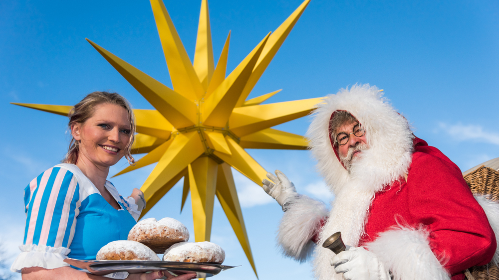 Stollenmädchen und Weihnachtsmann vor dem riesigen Herrnhuter Weihnachtsstern.  Foto: Sebastian Thiel