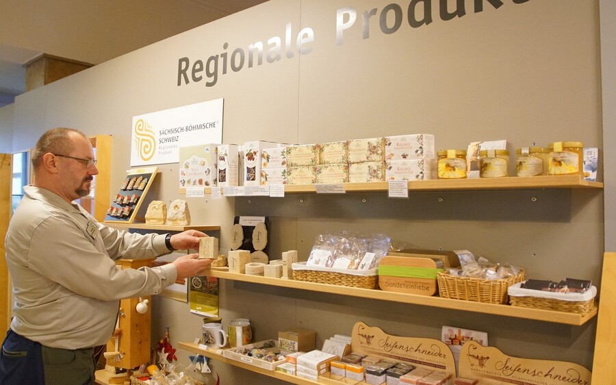 Steffen Hentschel, Mitarbeiter der Besucherinformation des NationalparkZentrums, präsentiert im Naturshop ausgewählte Produkte, die sich auch sehr gut als Weihnachtsgeschenk eignen.  Foto: K. Partzsch