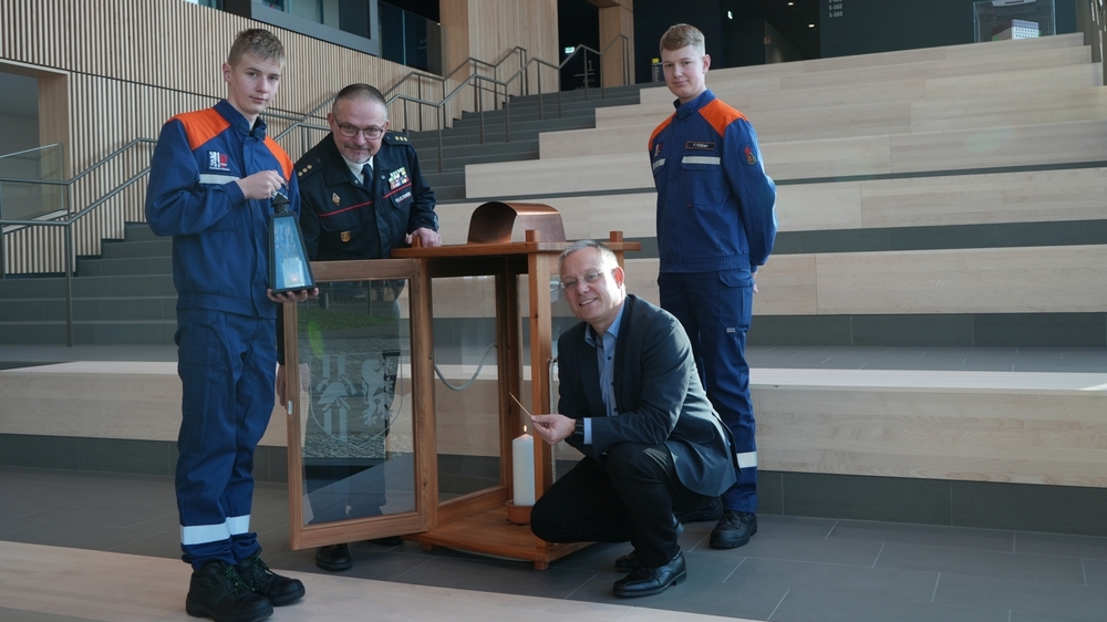 Wirtschaftsbürgermeister Jan Pratzka entzündet das Friedenslicht im Stadtforum. Carsten Löwe vom Stadtfeuerwehrverband und die beiden Mitglieder der Jugendfeuerwehr Cossebaude Florian Rößler (rechts) und Lucius Rüdiger holten das Licht aus Oberösterreich nach Dresden.. © Frida Kraus