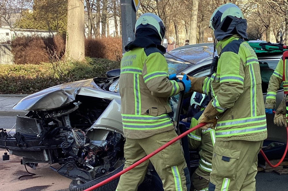 © Feuerwehr Dresden Einsatzkräfte beginnen mit hydraulischen Rettungsgeräten die Tür der Fahrerseite zu entfernen.