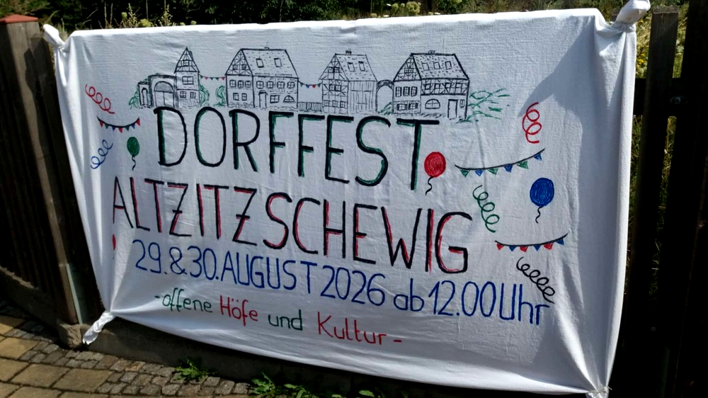 Schon am Eingang des Dorfplatzes lädt ein liebevoll gestaltetes Banner zum Jubiläumsfest ein. Foto:privat